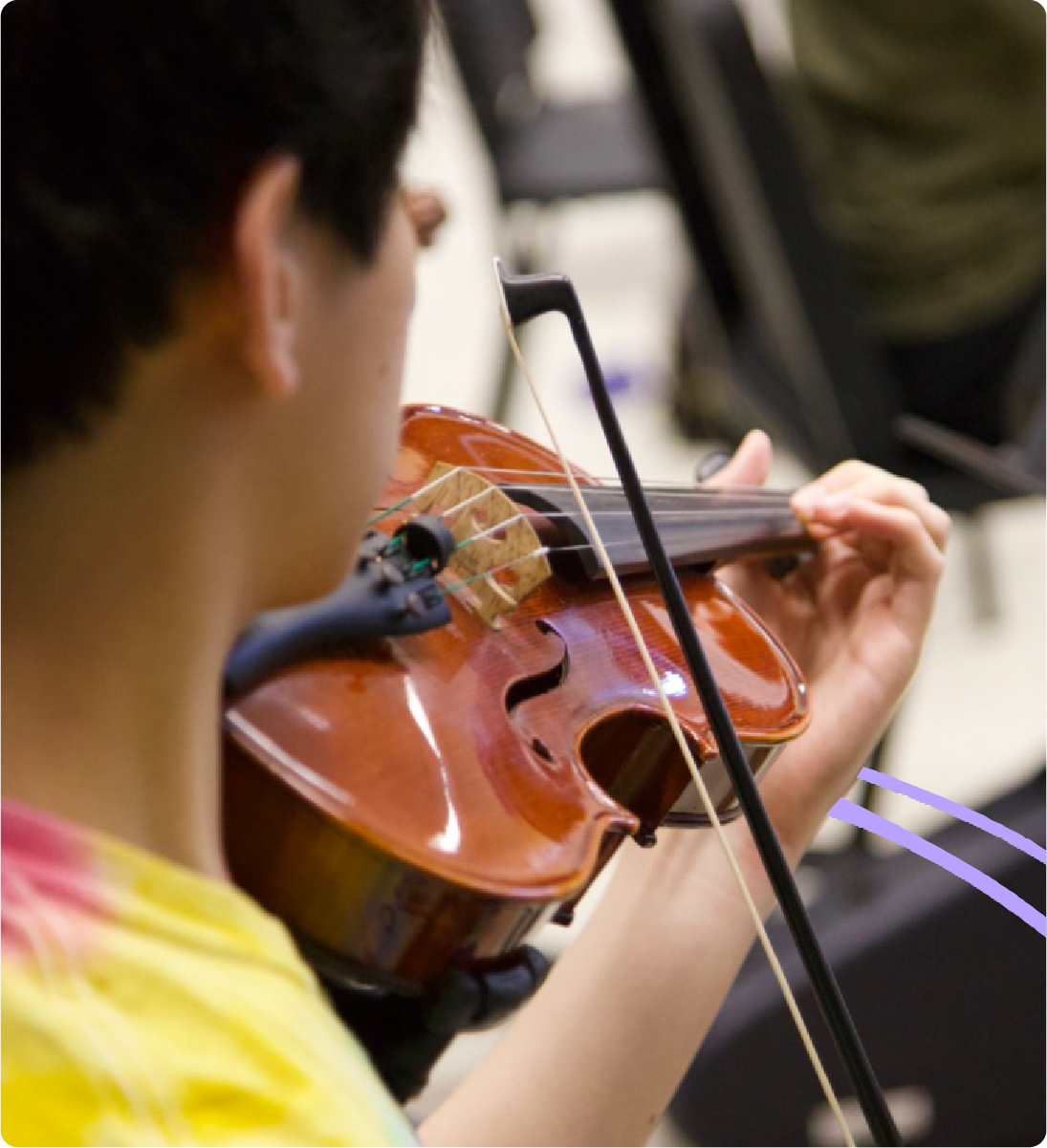 Student playing violin in classroom setting